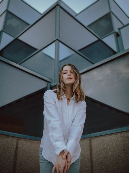 Free Portrait of a stylish woman posing against a modern architectural backdrop in Des Moines, IA. Stock Photo