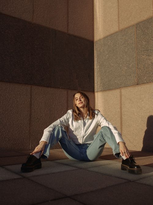 Free Stylish woman in casual wear sits against geometric architecture in Des Moines, Iowa. Stock Photo