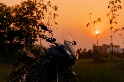 Free Black and Gray Motorcycle on Green Grass Field during Sunset Stock Photo