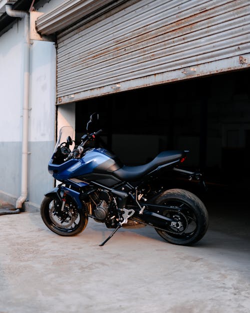 Free Black and Blue Sports Bike Parked Beside White Building Stock Photo