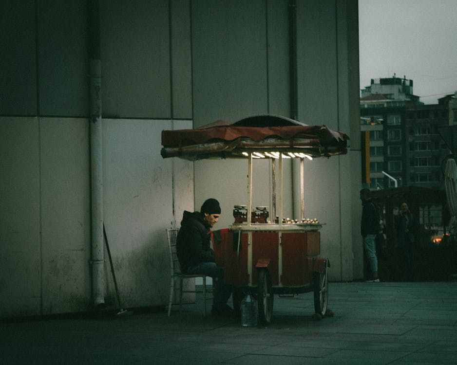 Man in Black Jacket Selling on the Street