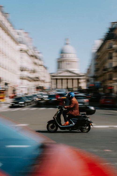 Free Man Riding a Scooter on the Road Stock Photo