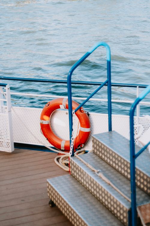 Free A serene boat deck with a lifebuoy overlooking calm waters. Stock Photo