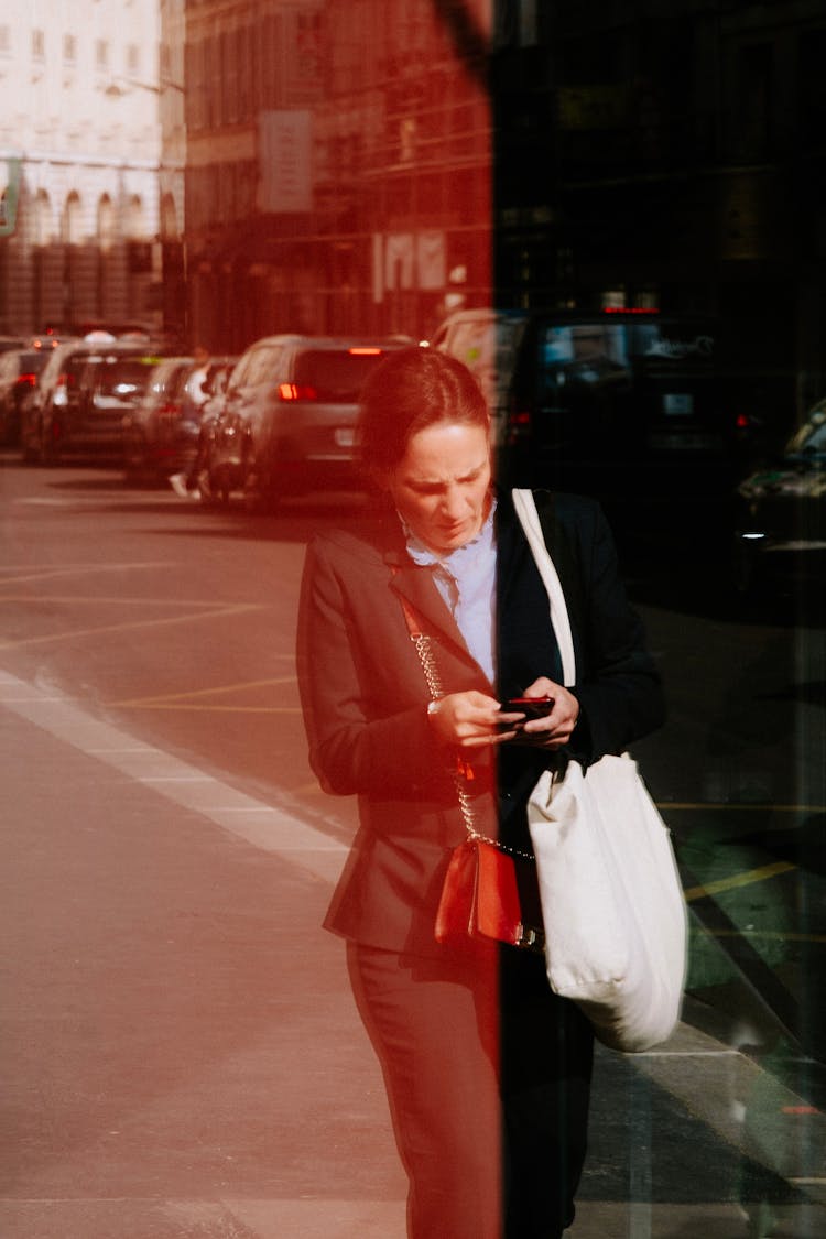 Woman Walking On A Street Reflecting In A Window 