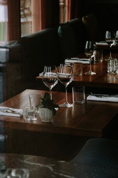 Sophisticated restaurant table setup with wine glasses, cutlery, and cozy ambiance.