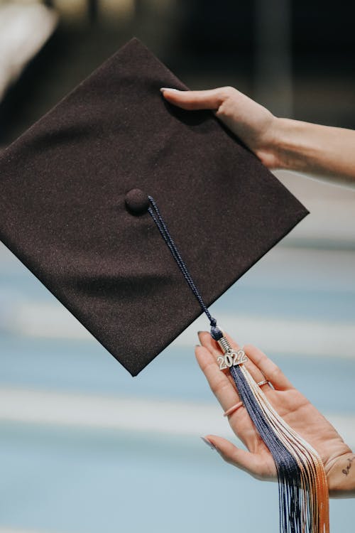 Hands Holding Graduation Hat