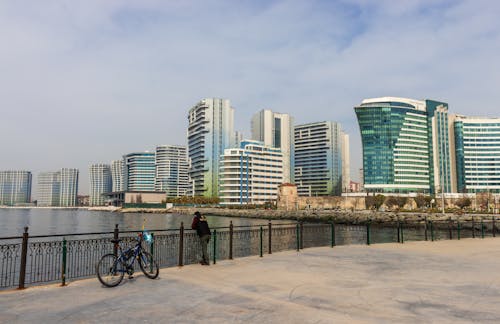 Man on the Promenade Near City Buildings