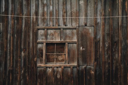Free Close-up of a rustic wooden window set in a weathered brown barn wall in Ukraine. Stock Photo