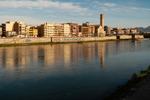 Free A vibrant cityscape with a bridge and clear reflections on the river under a bright sky. Stock Photo