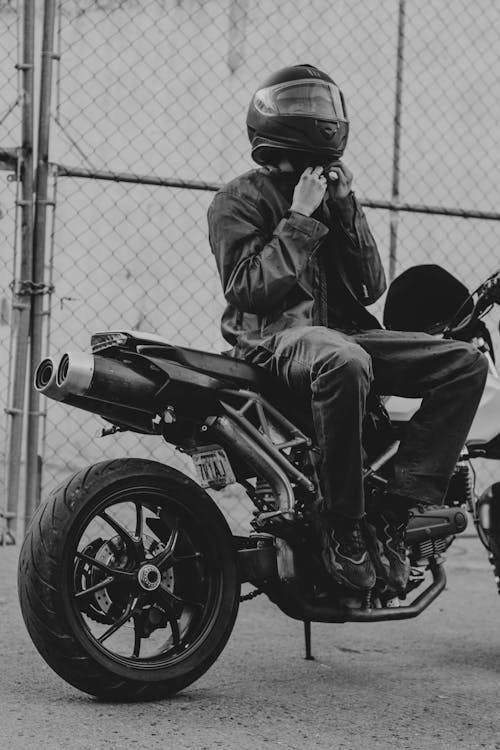 Black and White Photo of a Man Sitting on a Motorcycle