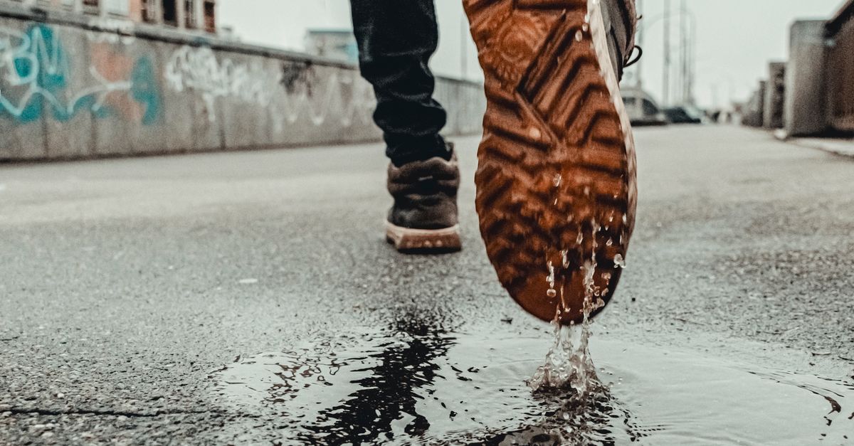Person Stepping on a Puddle · Free Stock Photo