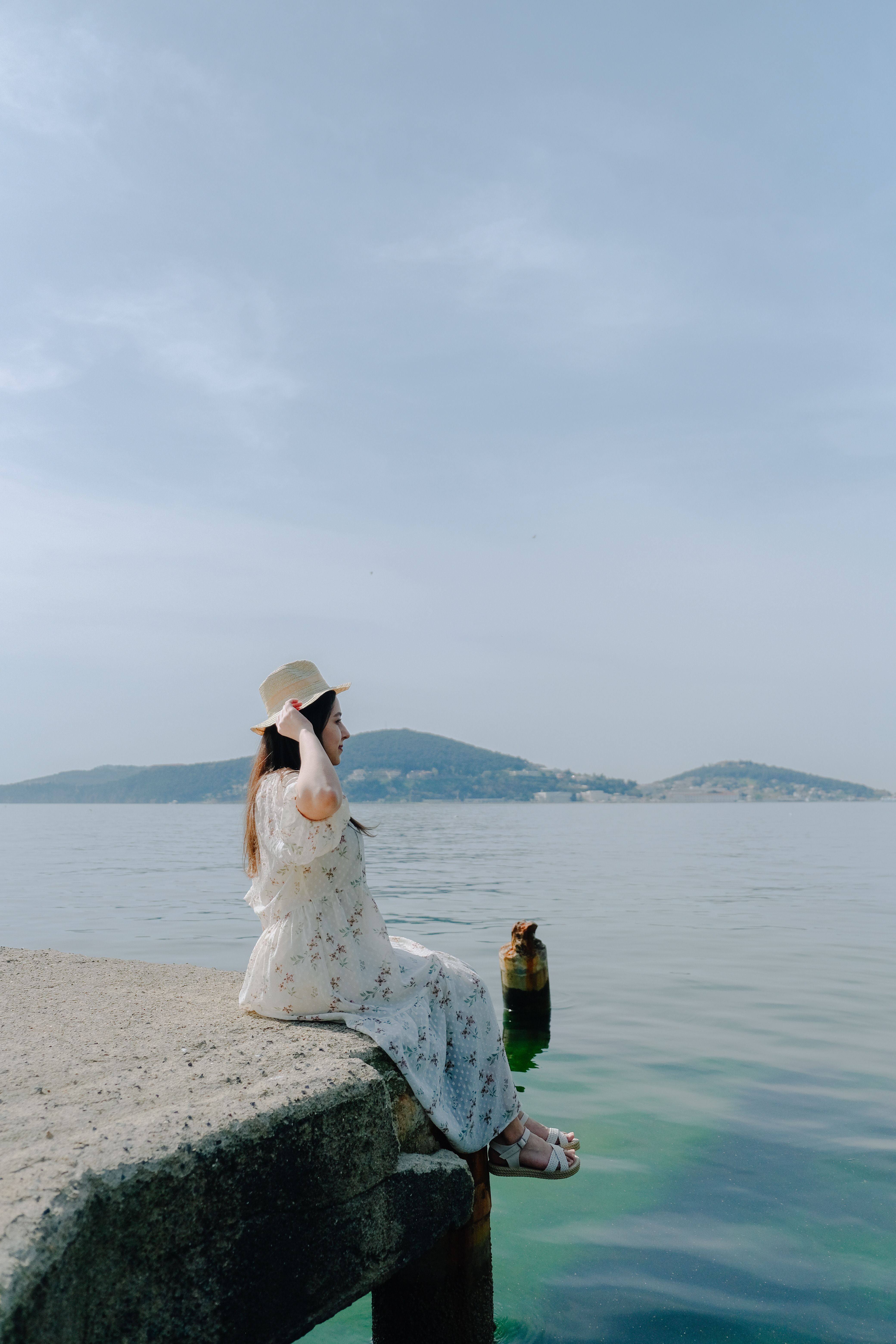 Woman Sitting on a Concrete by the Sea · Free Stock Photo