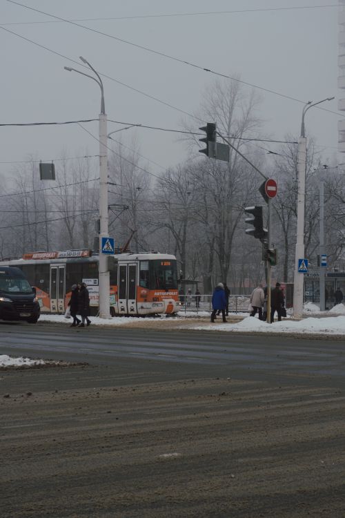 Free A wintery street in Vitebsk, Belarus with a tram, people crossing, and traffic lights. Stock Photo