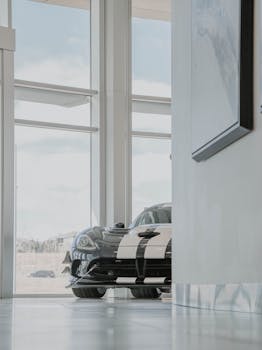 A sleek black and white sports car displayed in a modern glass showroom.
