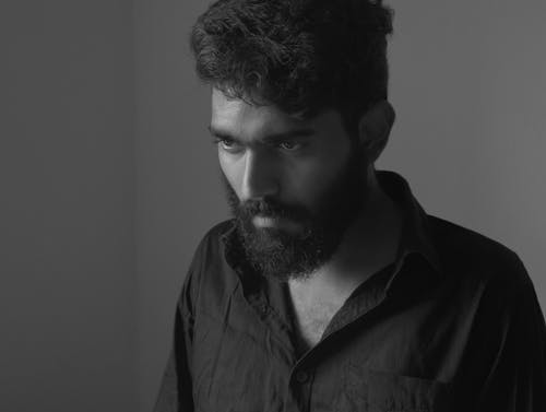 Grayscale Photo of a Bearded Man in Black Button-Up Shirt