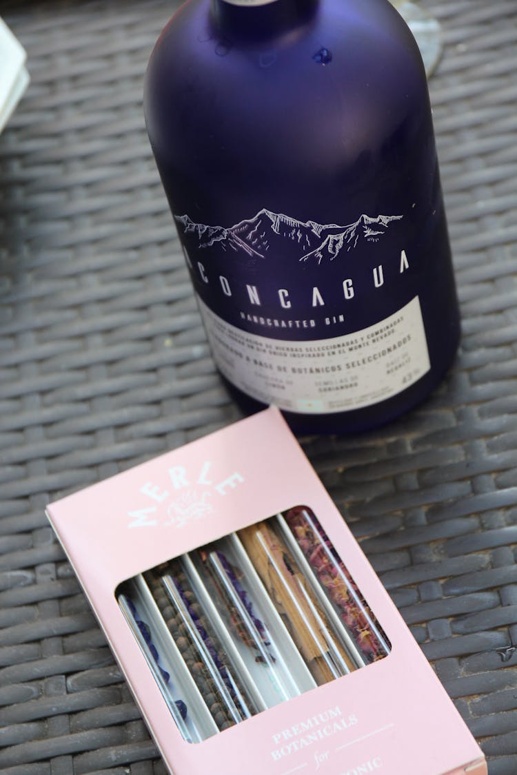 A Bottle Of Liquor Beside A Box Of Botanical Herbs