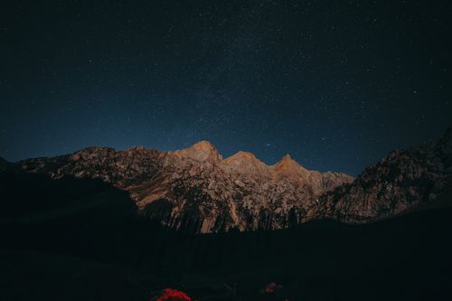 Free Capture of a starry night sky above a rugged mountain landscape, showcasing natural beauty. Stock Photo