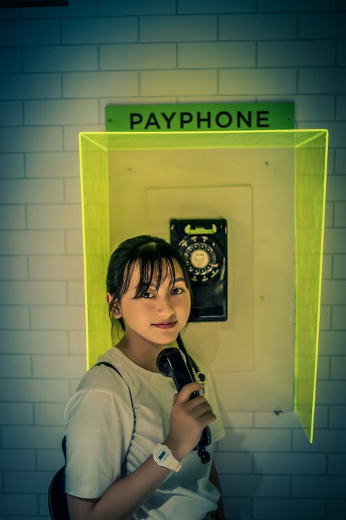 Free Photo of Woman Standing Beside Payphone. Stock Photo