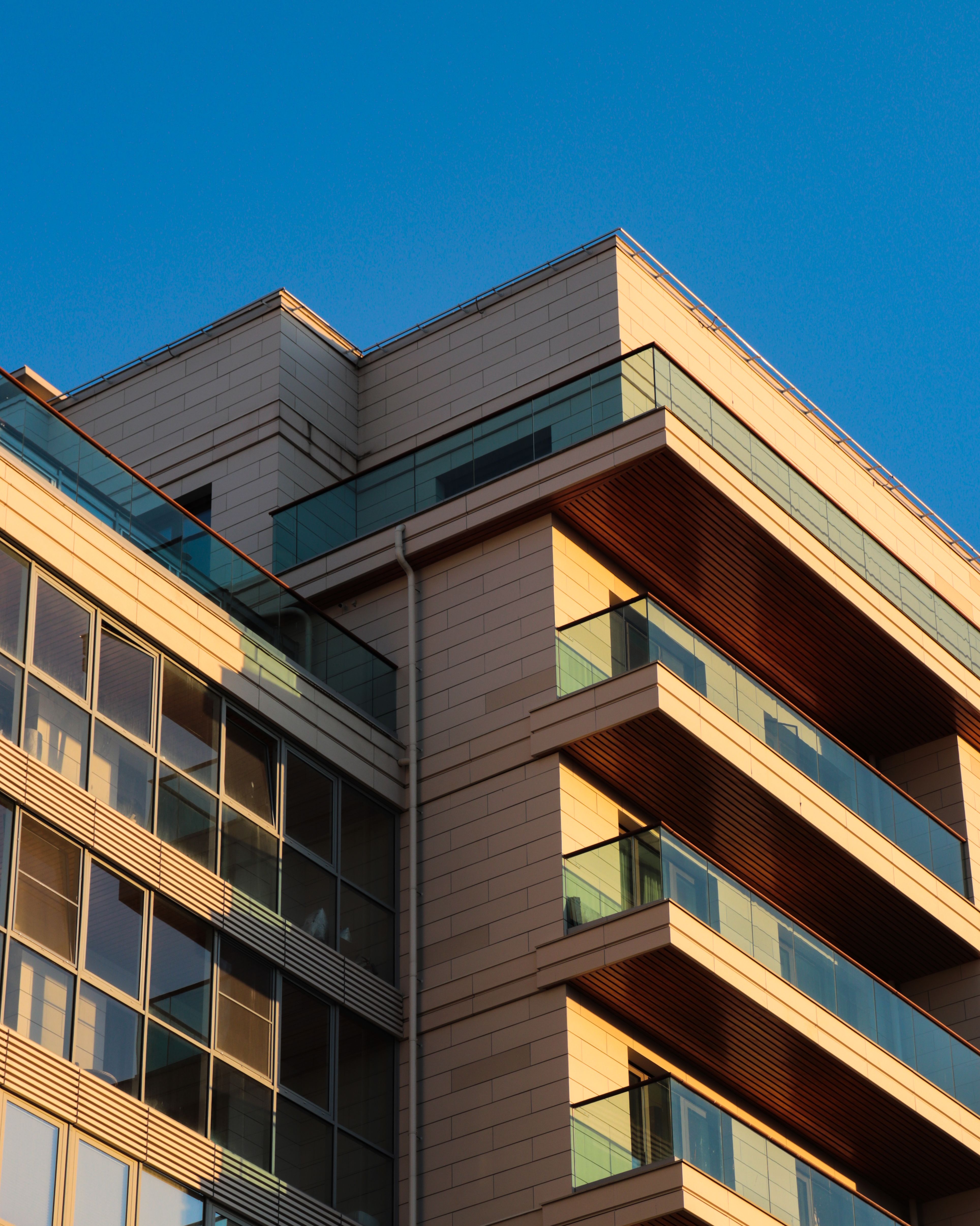 Façade d’un immeuble à condos moderne avec balcons sous un ciel dégagé