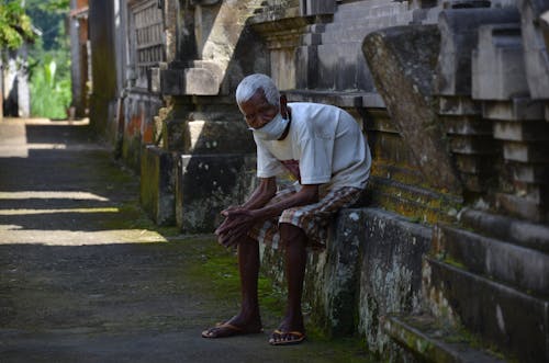 An Elderly Man Sitting while Wearing Face Mask