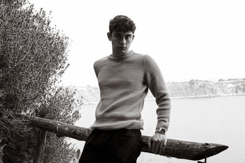 A Man in Sweater Leaning on a Railing