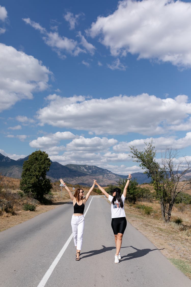 Friends Walking Together With Their Hands Up