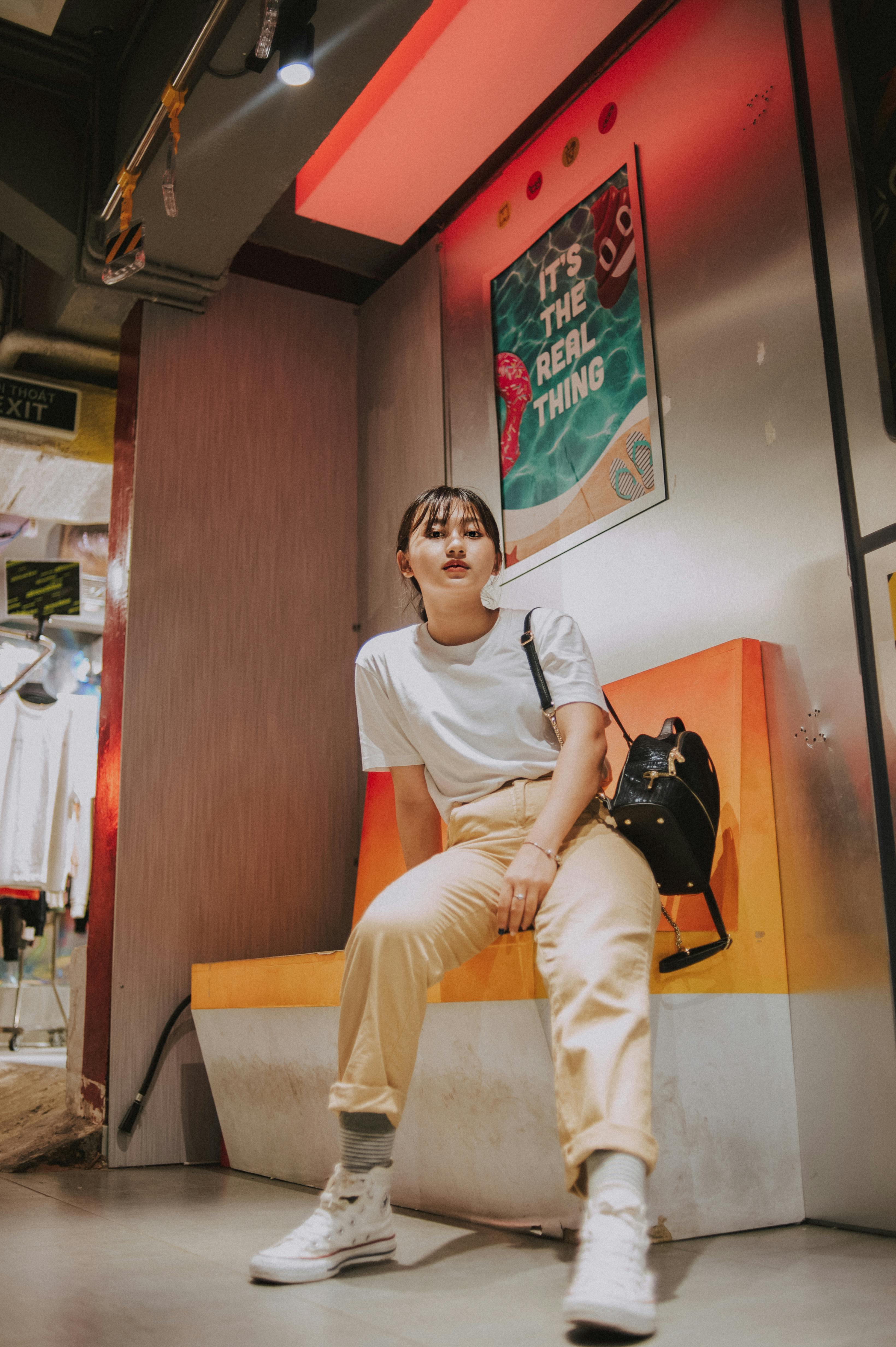 一位年轻时尚的女子在室内摆着姿势，散发出休闲自信的氛围