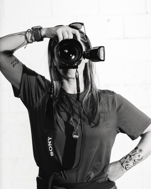 Free Black and white portrait of a woman photographer posing with a camera. Stock Photo