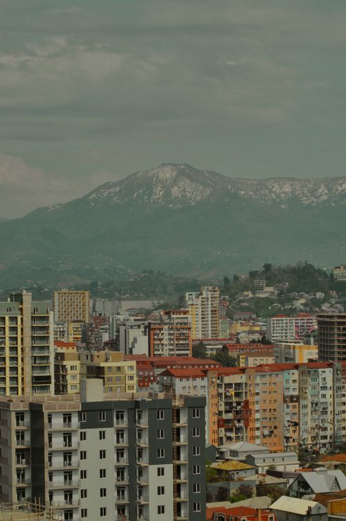 Free High-rise buildings in a city with distant mountains, an urban and natural blend. Stock Photo