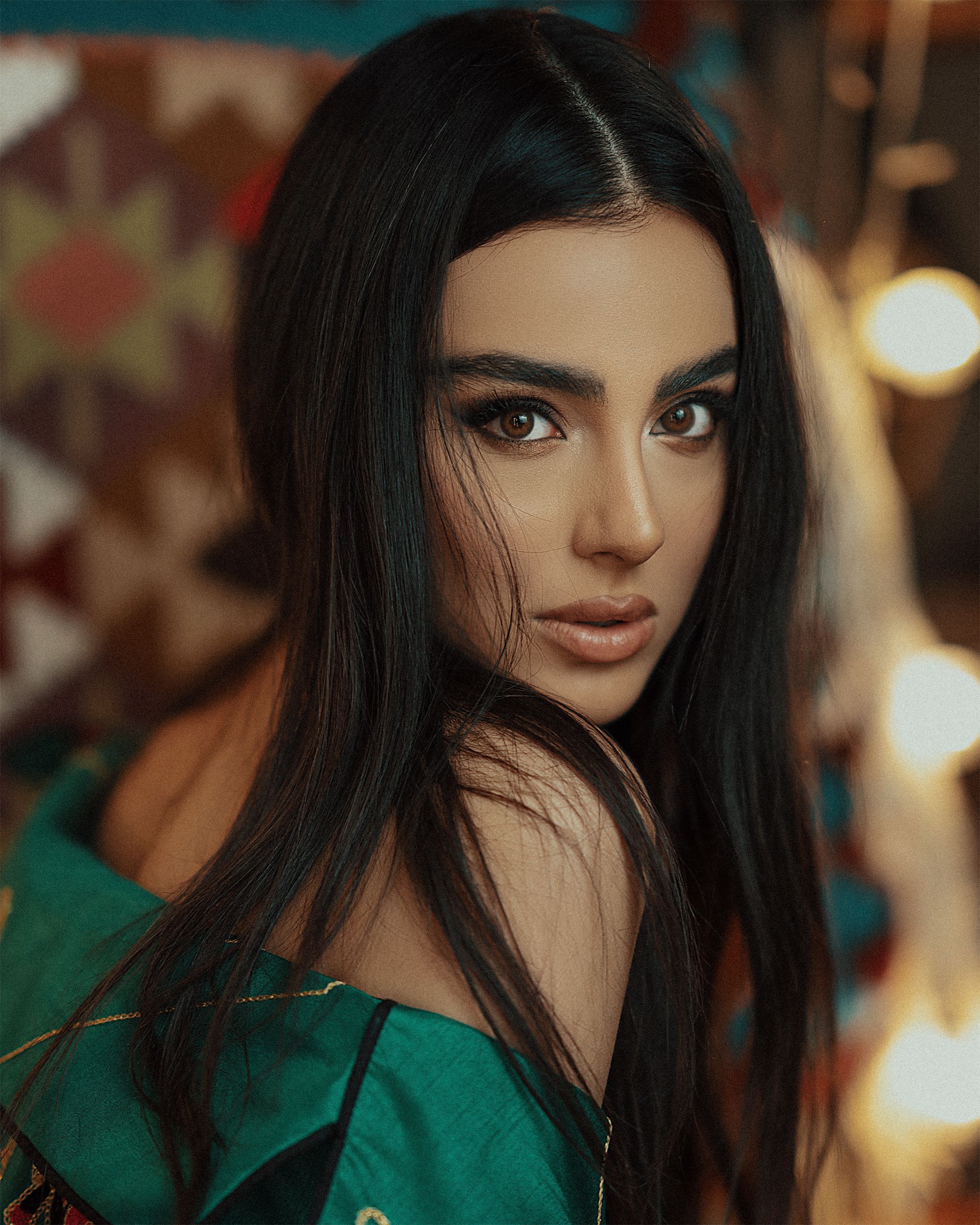 Stunning close-up portrait of a woman with long dark hair wearing a green dress.