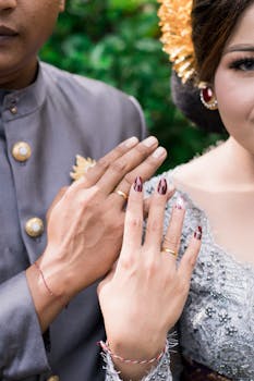 Close-up of a bride and groom showcasing gold wedding rings at their ceremony.