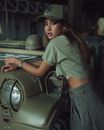 Woman in Khaki Outfit Leaning Against a Military Car 