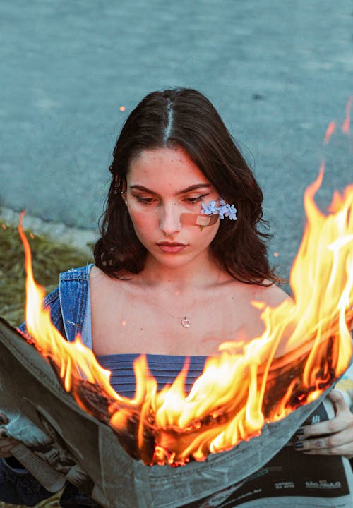 Free Woman Reading a Burning Newspaper Stock Photo