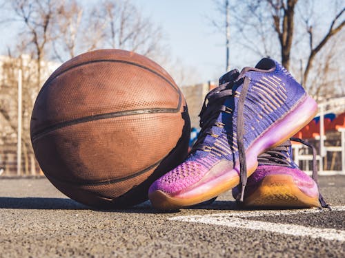 Close-Up Photography of Shoes Near Ball