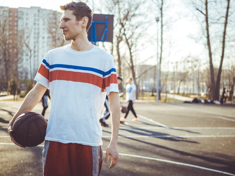 Man Wearing Shirt Holding Basketball In Court