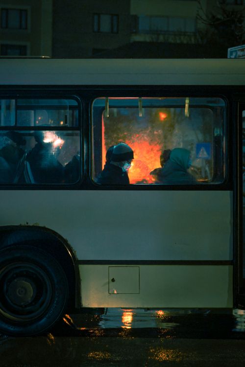Free Silhouetted commuters in a nighttime bus with moody lighting. Stock Photo