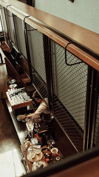 咖啡师在现代室内环境中准备咖啡，室内采用木质内饰和工业设计