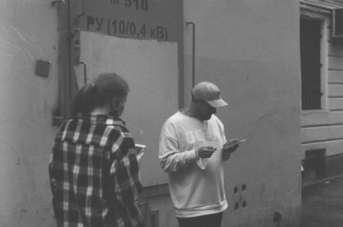 Free Two adults using smartphones in an urban black and white street scene. Stock Photo