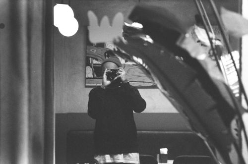 Free Monochrome image of a person taking a self-portrait with a camera in a mirror reflection. Stock Photo