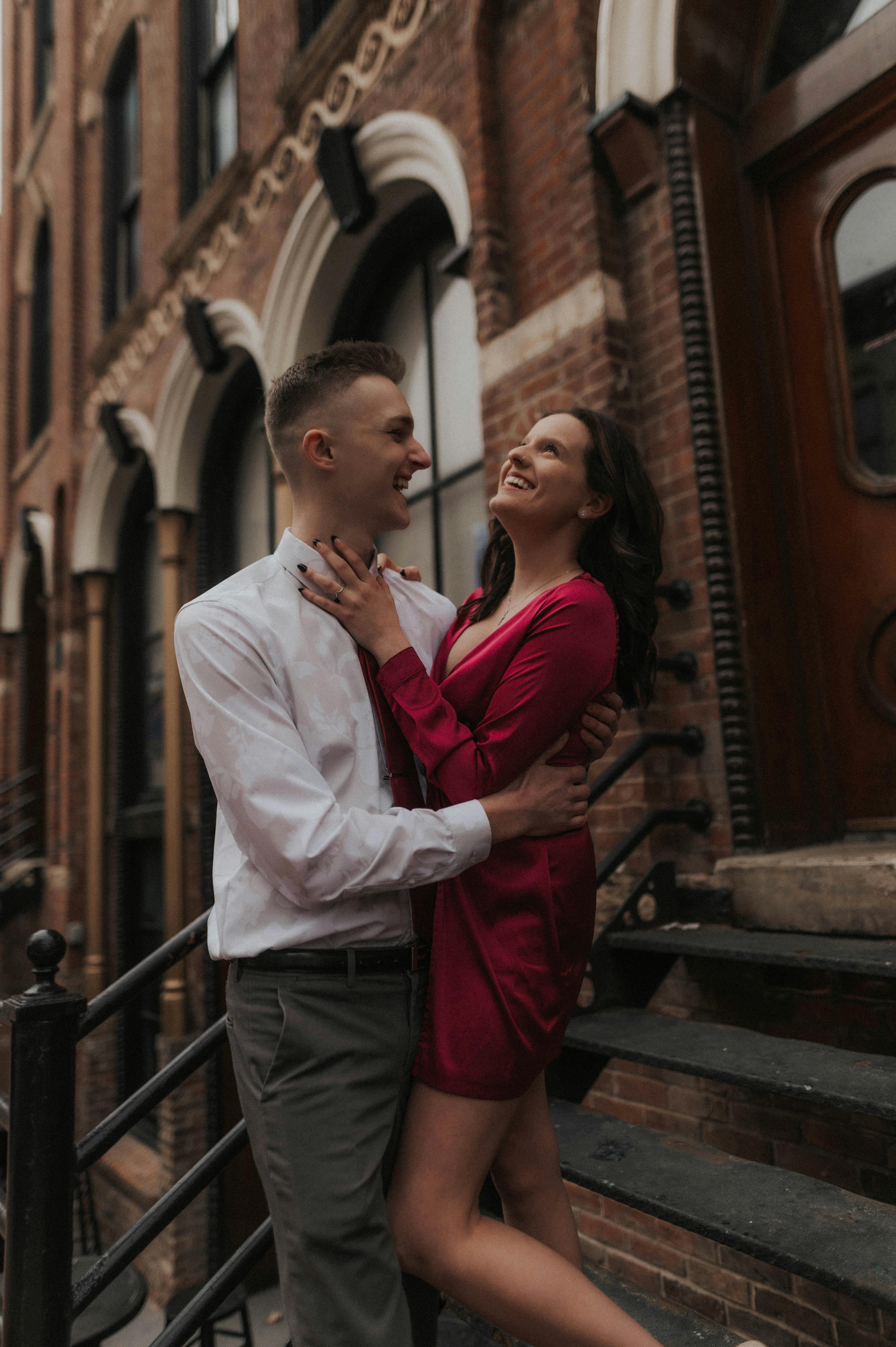 elegantly dressed couple standing holding each other and smiling