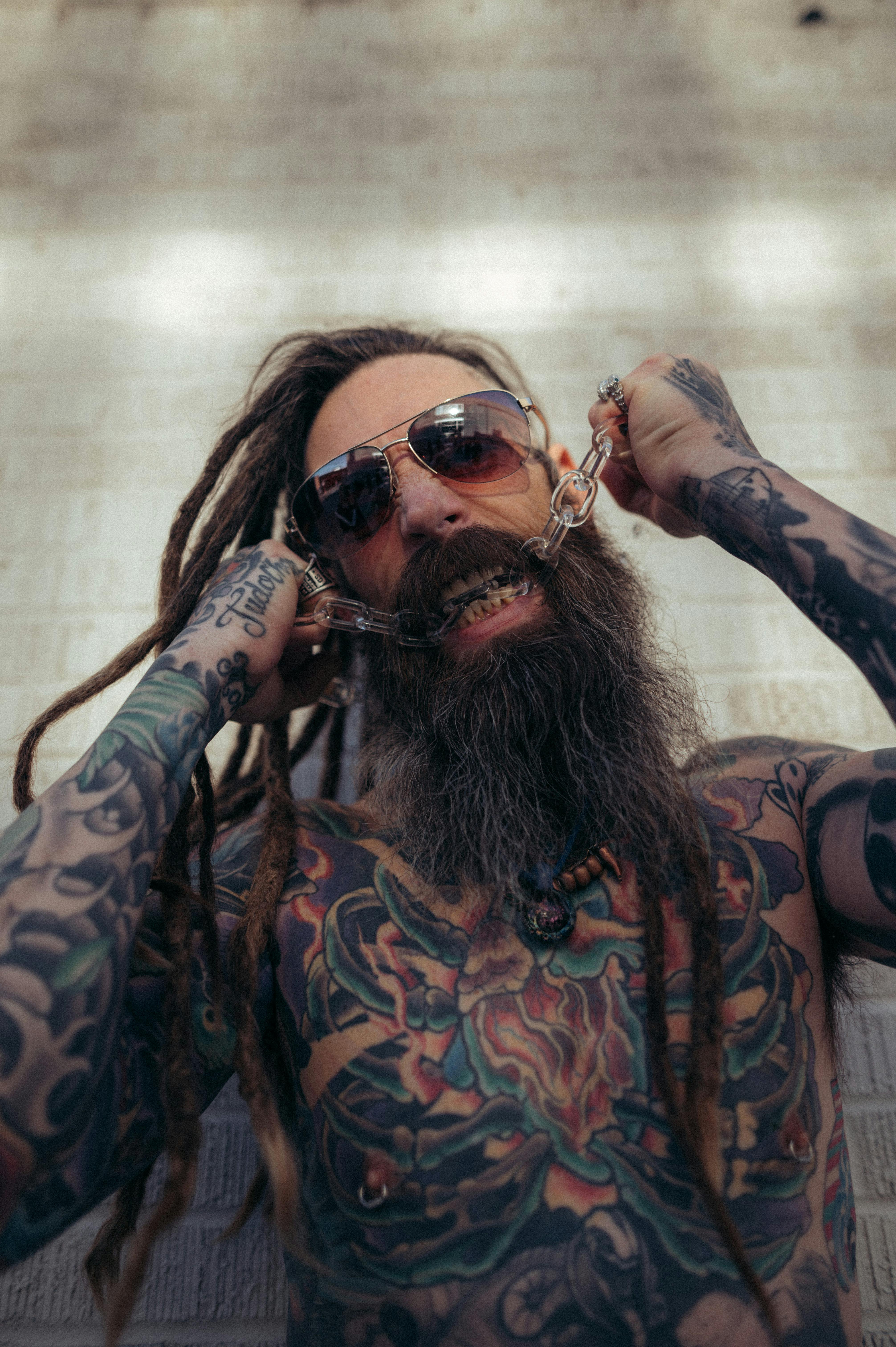 Man with Long Beard, Tattoos and Dreadlocks Sitting at a Bar Counter · Free  Stock Photo