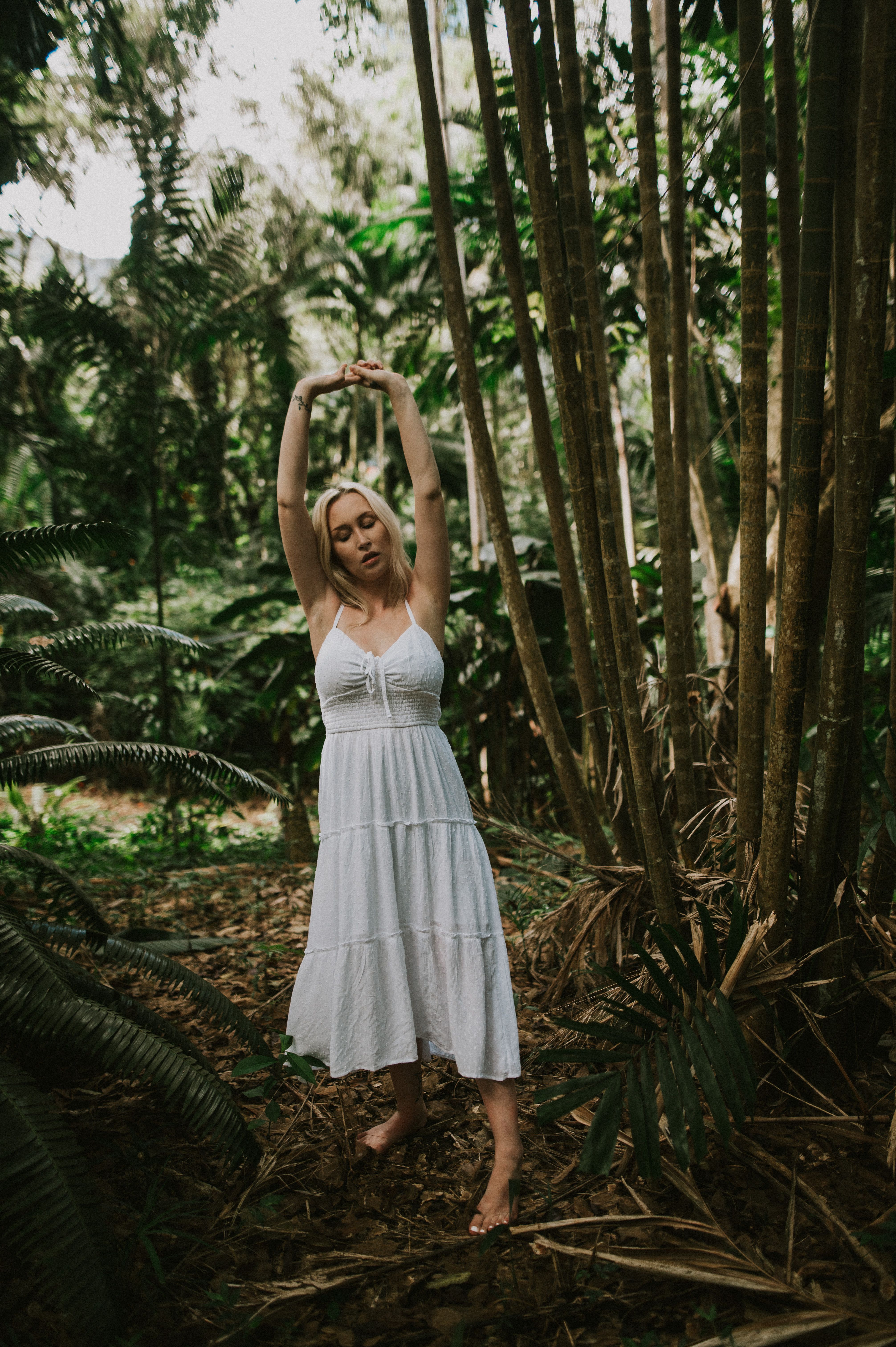 Woman in White Dress Standing Next to Bamboo Trees · Free Stock Photo