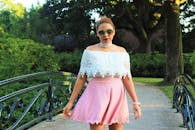 光天化日之下，一名身着时尚服装的年轻女子在花园桥上自信地摆着姿势