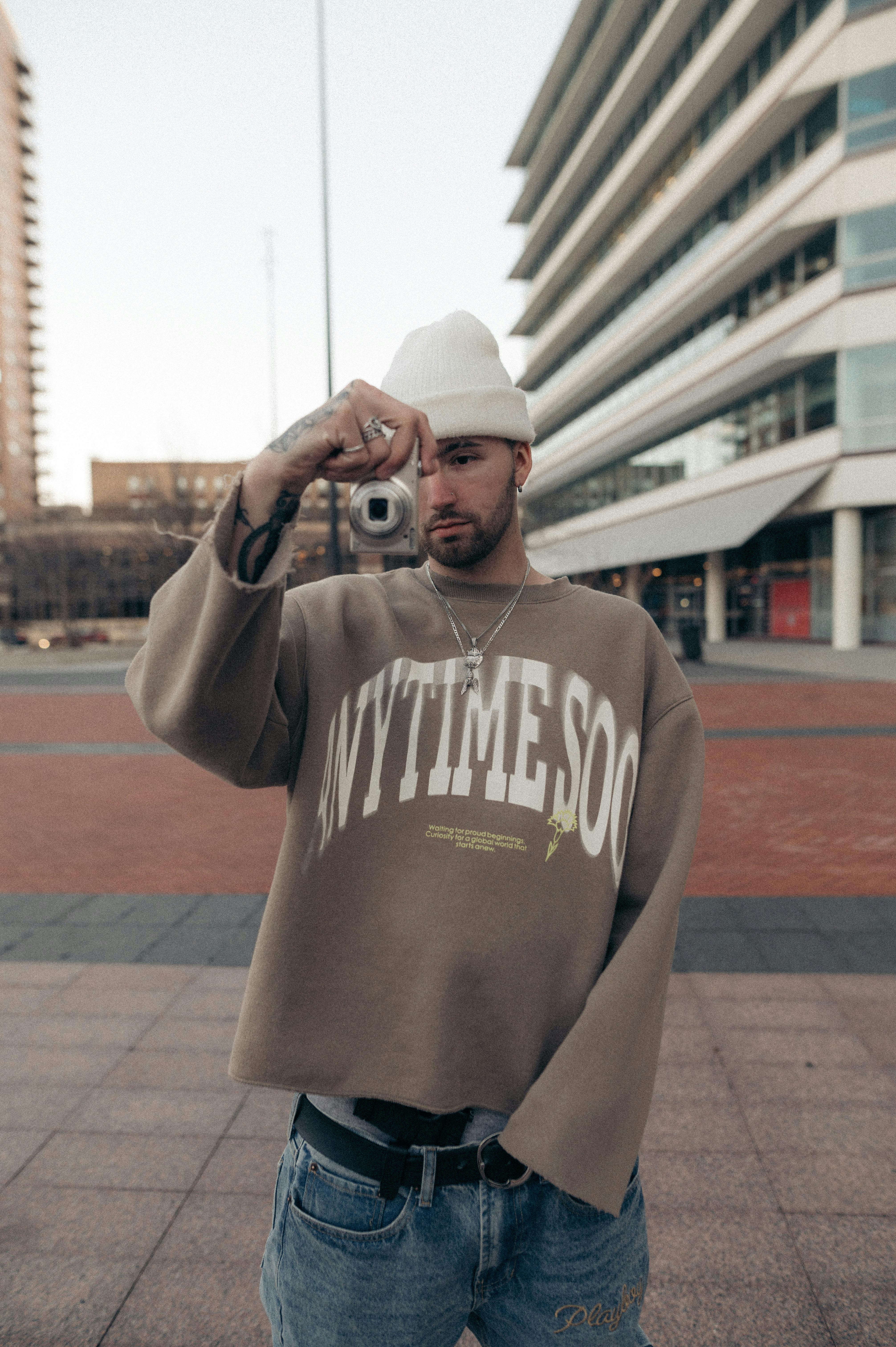 Free Young Man in White Knitted Hat Taking Shot with Photo Camera  Stock Photo