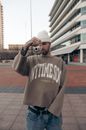Young Man in White Knitted Hat Taking Shot with Photo Camera 