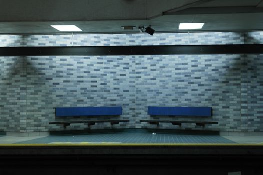 Empty subway platform in Montreal with unique brick wall pattern and benches.