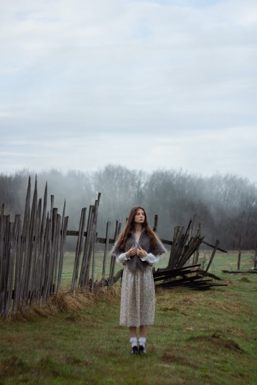 A Woman Standing on Grass Field