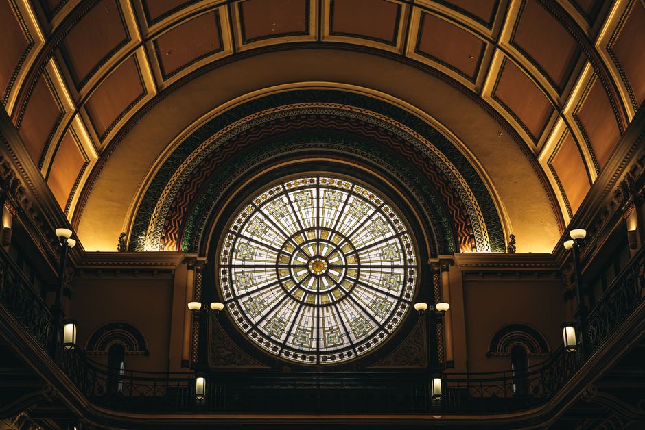 Elegant stained glass dome inside a historic train station with intricate architectural details.