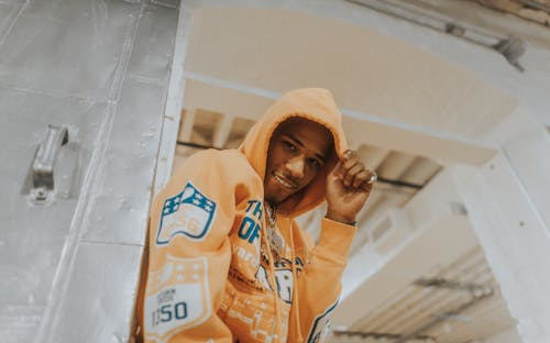 Kostenloses Stock Foto zu afroamerikanischer mann, gelber hoodie, lächeln