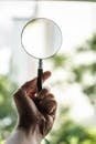 Tilt Shift Lens Photography of Person Holding Magnifying Glass